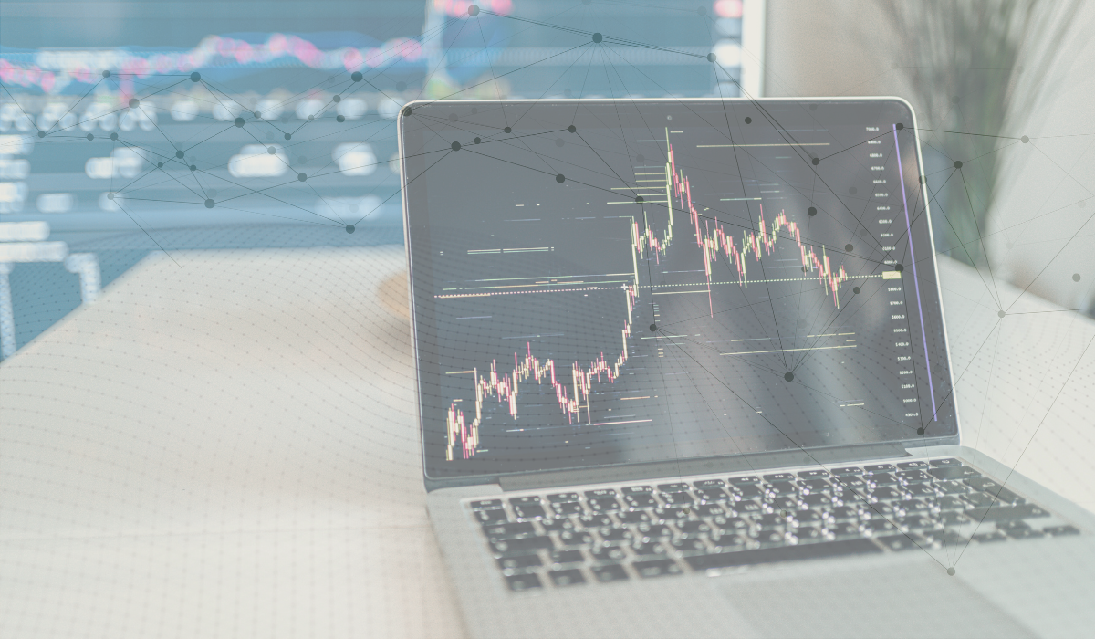 Up close photo of someone typing on a laptop. There's overlay of graph lines and a dotted wave.